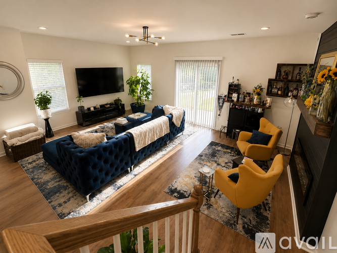 A living room with a blue couch and a television on the wall.