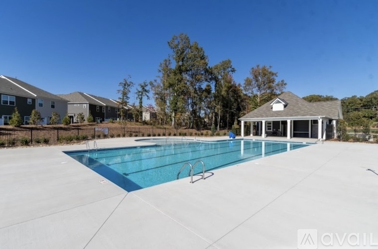 A large outdoor swimming pool with a diving board and a small pavilion.