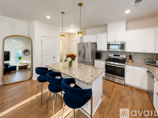 A kitchen with a large island and blue chairs.