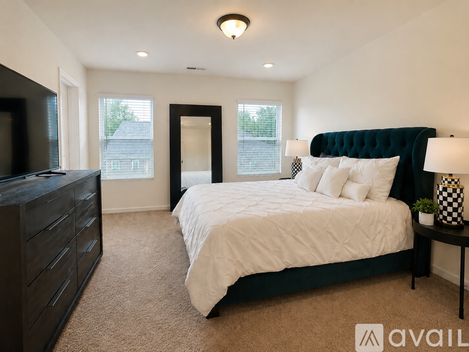 A bedroom with a large bed, a dresser, and a window.