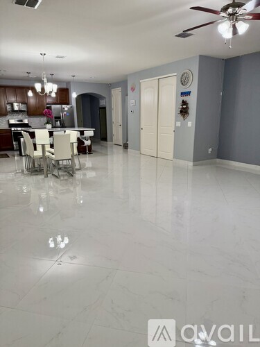 A spacious room with a dining table and chairs.