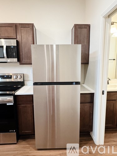 A stainless steel refrigerator stands in a kitchen.