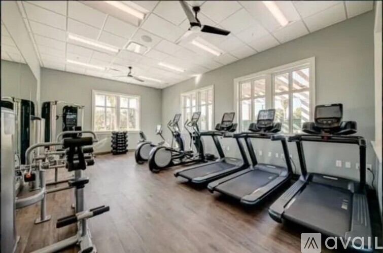 A gym with treadmills, elliptical machines, and other exercise equipment.