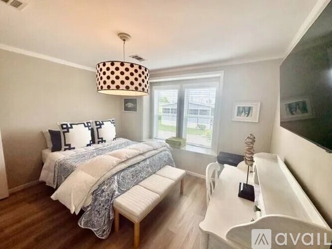 A bedroom with a large bed and a bench.