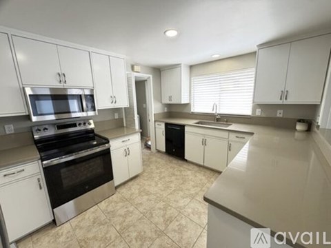 A kitchen with white cabinets and appliances.