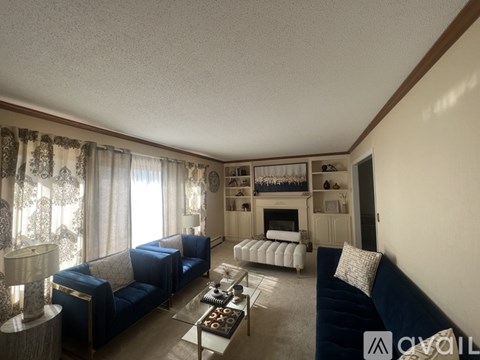 A living room with a blue couch and a fireplace.