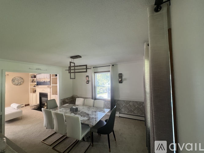 A dining room with a table set for six and a couch in the background.