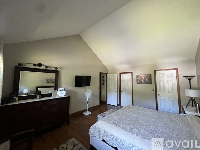 A bedroom with a large bed and a vanity with a mirror.