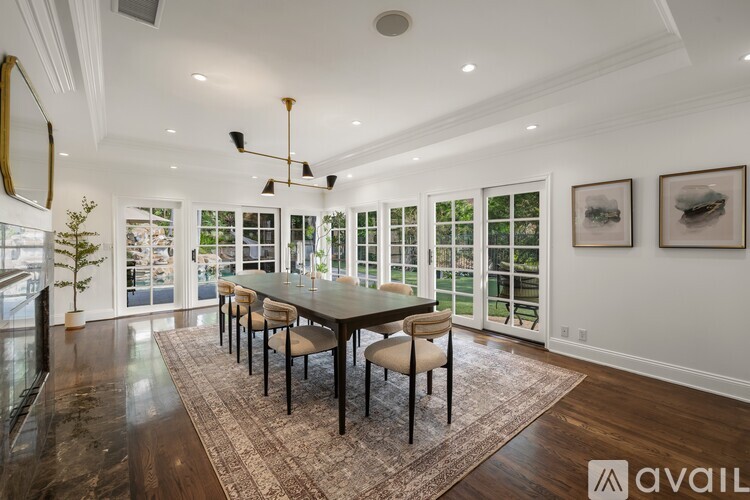 A dining room with a large table and chairs.