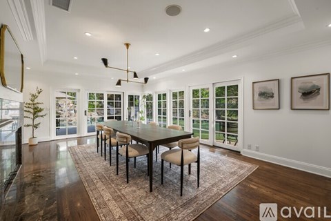 A dining room with a large table and chairs.