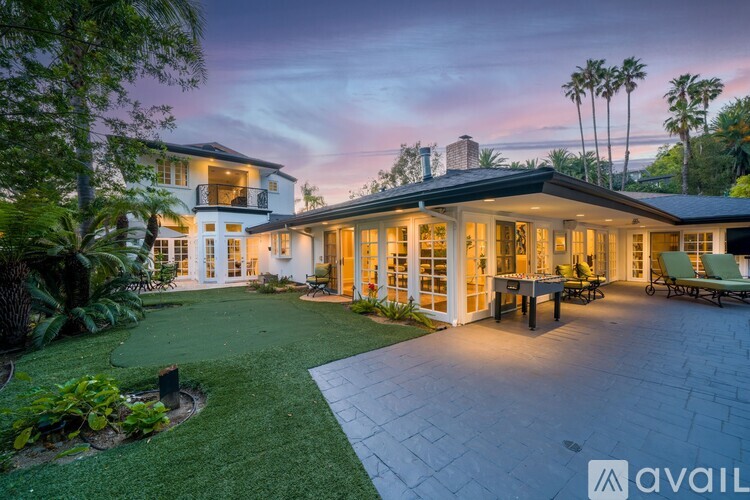 A modern house with a spacious backyard and patio area.