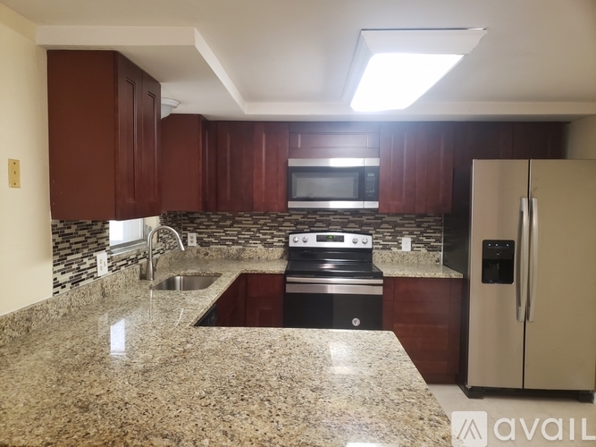 A kitchen with granite countertops and a stainless steel oven.