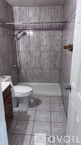 A bathroom with a toilet, a bathtub, and a shower.