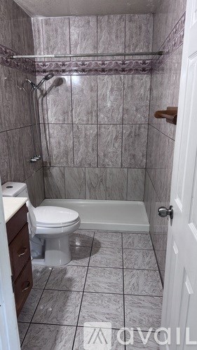 A bathroom with a toilet, a bathtub, and a shower.