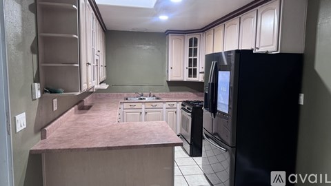 A kitchen with black appliances and white cabinets.