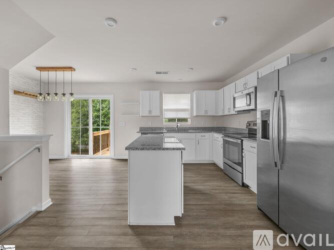 A modern kitchen with stainless steel appliances and white cabinetry.