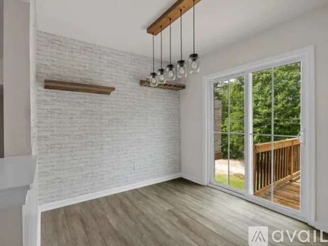 A hallway with a staircase on the left and a door on the right.