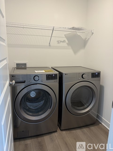 Two front loading washing machines in a small laundry room.