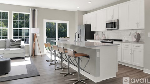 A modern kitchen with white cabinets and a large island.