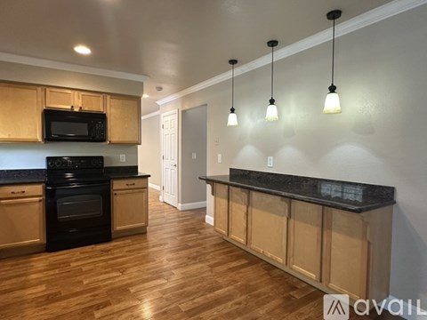 A kitchen with wooden cabinets and black appliances.