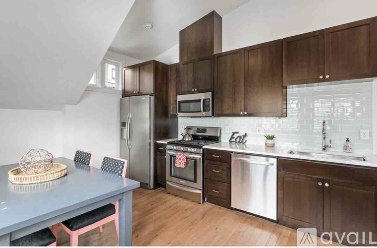A kitchen with brown cabinets and a blue table.