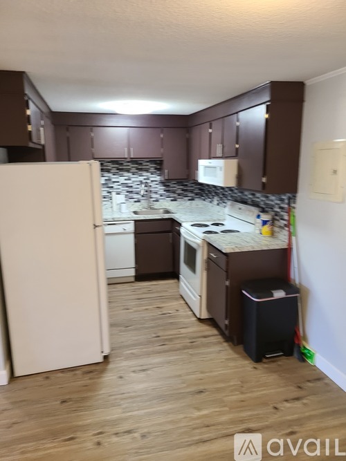 A kitchen with brown cabinets and a white refrigerator.