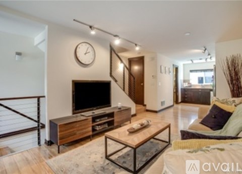 A living room with a television and a glass coffee table.