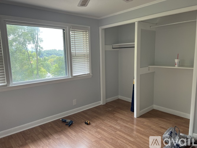 A room with a window and a wooden floor.