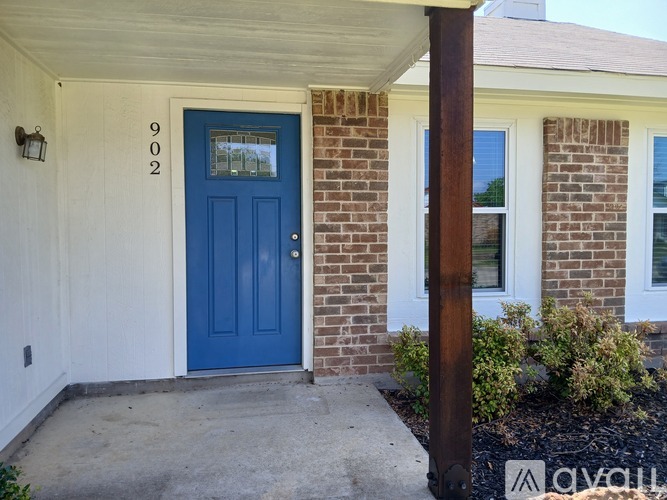 A blue door with the number 902 on the wall above it.