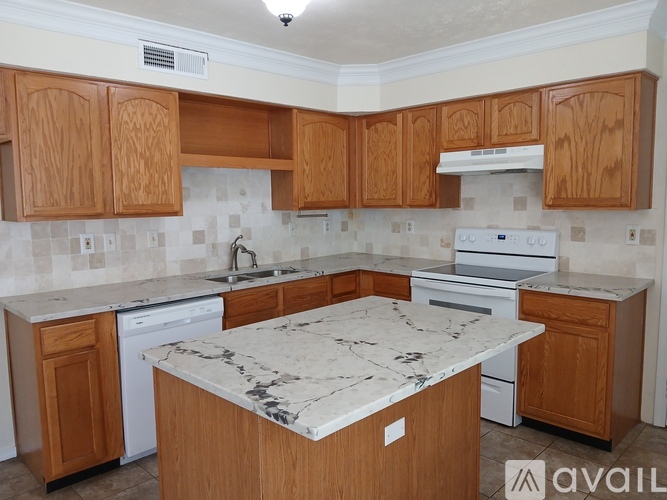 A kitchen with wooden cabinets and a marble countertop.