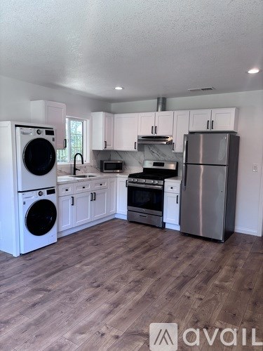 A kitchen with white cabinets and a wooden floor.
