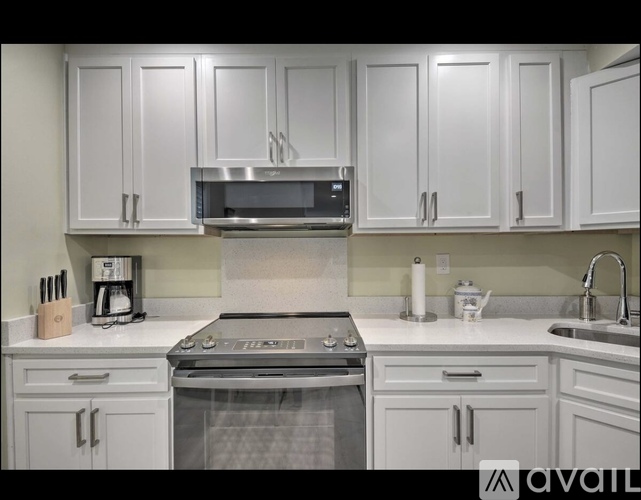 A kitchen with white cabinets and a stainless steel oven.