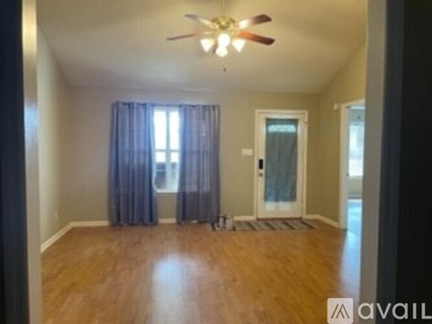 A room with a ceiling fan and a door.