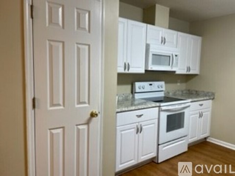 A kitchen with white cabinets and appliances is available for rent.