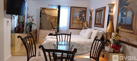 A bedroom with a bed, dresser, mirror, and chairs.