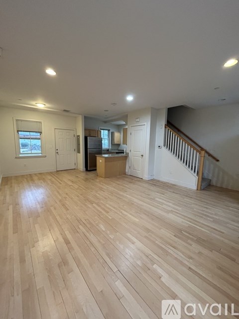 A room with wooden flooring and white walls.