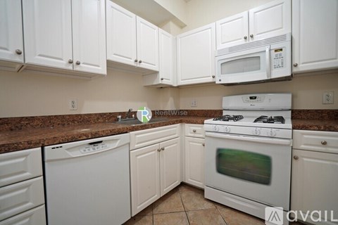 A kitchen with white cabinets and appliances.