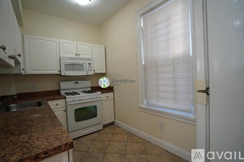 A kitchen with granite countertops and white appliances.