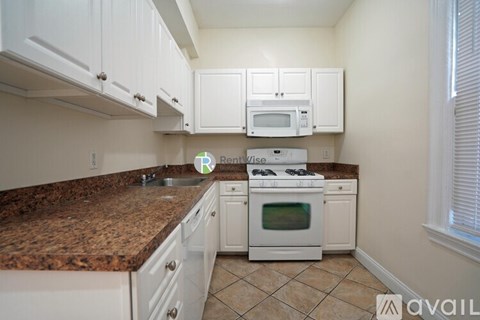 A kitchen with granite countertops and white cabinets.