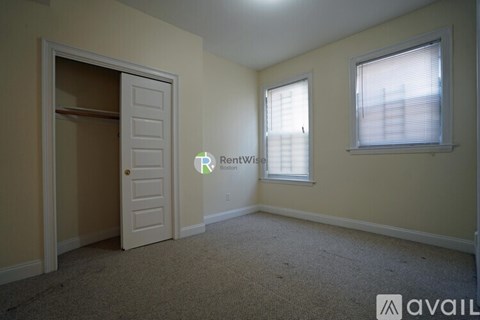 A room with a door, window, and carpeted floor.