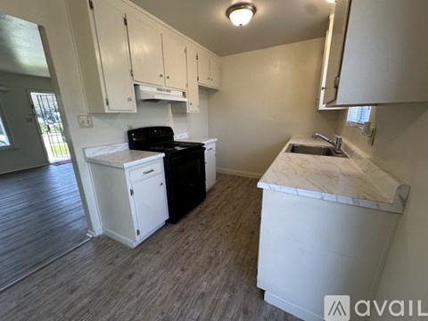 A kitchen with white cabinets and a black stove top oven.