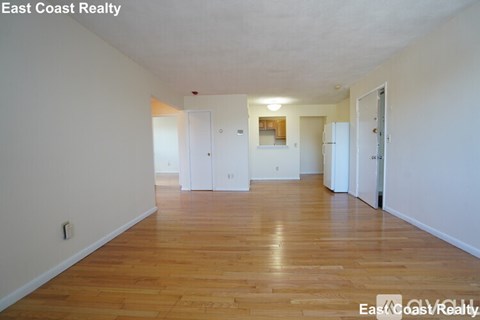 Empty room with wooden floors and white walls.