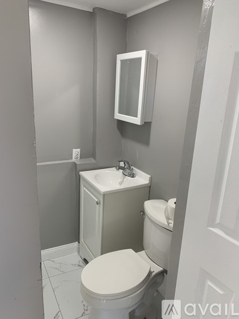 A white toilet sits next to a sink in a bathroom.