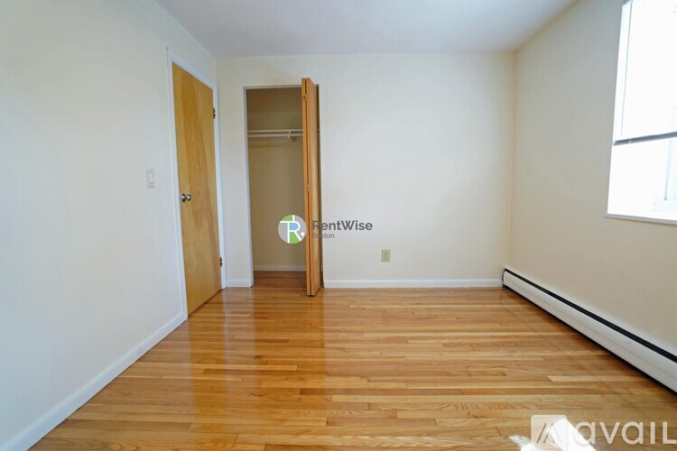 A room with wooden floors and a door leading to another room.