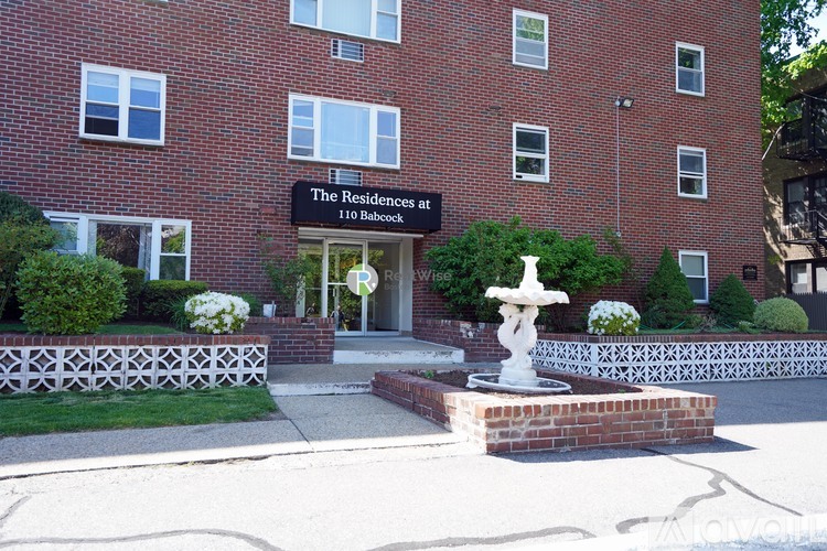 A red brick building with a sign that says "The Residences at 110 Babcock".