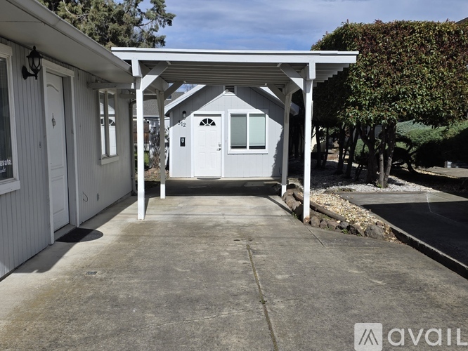 A white house with a porch and a covered walkway.