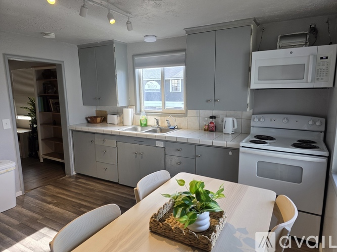 A kitchen with a table and chairs in front of it.
