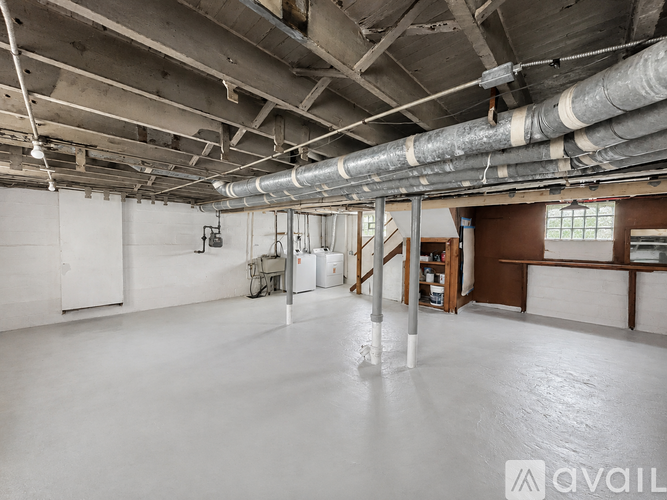 A large, empty industrial space with white walls and a concrete floor.