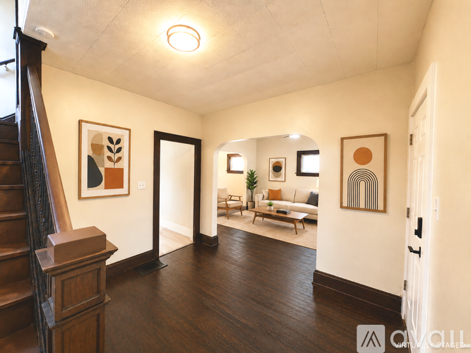 A living room with a couch, a chair, a coffee table, and a painting on the wall.