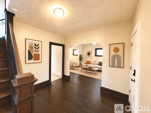 A living room with a couch, a chair, a coffee table, and a painting on the wall.